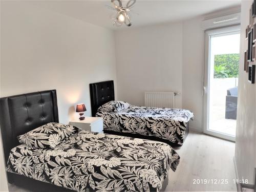 zwei nebeneinander stehende Betten in einem Schlafzimmer in der Unterkunft l'Etoile du Nord in Romainville