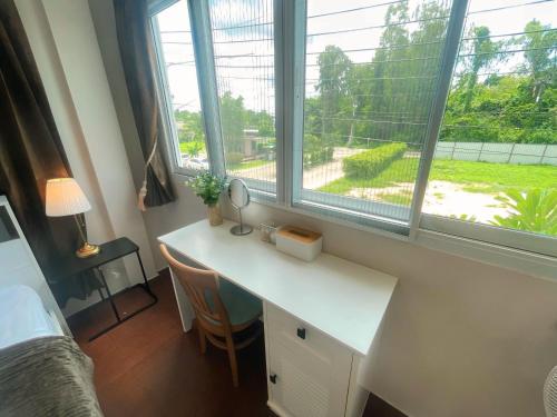 a bedroom with a desk and a window and a bed at Private Pool Getaway - Baan Hug Ubon Warinchamrap in Ubon Ratchathani
