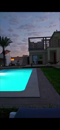 a large swimming pool in front of a house at Villa DEJRBA De LUXE in Houmt Souk