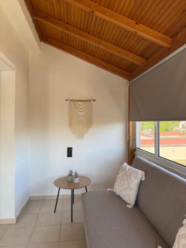 a living room with a couch and a table at BLOOM Studios in Achillion Magnisia