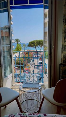 a room with a balcony with a view of the ocean at Hôtel Eden - La Baigneuse in Juan-les-Pins