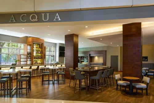 a restaurant with tables and chairs and a bar at The Woodlands Waterway Marriott Hotel and Convention Center in The Woodlands