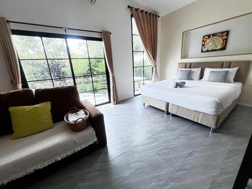 a bedroom with a bed and a couch at บ้านต้นลมสุวรรณภูมิ Baantonlom suvarnabhumi in Ban Khlong Thewa