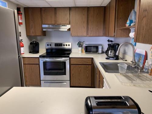 a kitchen with wooden cabinets and a stove top oven at Ocean Block, Ship Bottom, Pool, Beach Badges, Wifi, Washer Dryer, 12186 in Ship Bottom