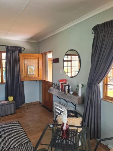 a living room with a table and a mirror at Meadow View Retro Accommodation in Wakkerstroom
