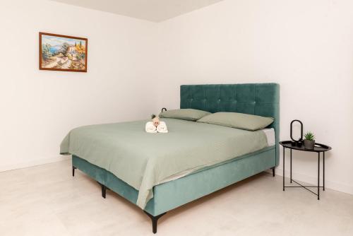 a bedroom with a green bed with two stuffed animals on it at Luxury Grey house in Stolac