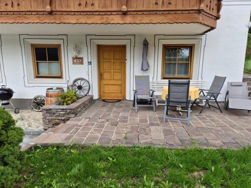 a patio with chairs and a table in front of a house at Gruber Alexandra, Appartement mit Lungaucard in Sankt Michael im Lungau