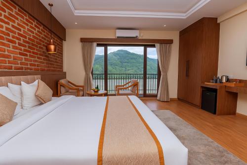 a bedroom with a bed with a view of a mountain at Temple Himalaya Hotel & Spa in Pokhara