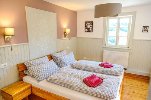 two beds in a room with red pillows on them at Ferienhaus Ottenhöfen - Sauna | Hot Tub in Ottenhöfen