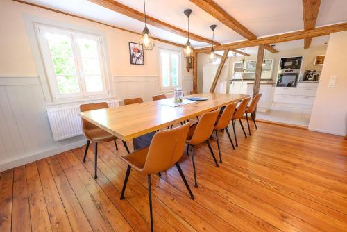a dining room with a large wooden table and chairs at Ferienhaus Ottenhöfen - Sauna | Hot Tub in Ottenhöfen