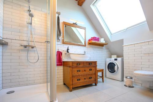 a bathroom with a sink and a shower and a washing machine at Ferienhaus Ottenhöfen - Sauna | Hot Tub in Ottenhöfen