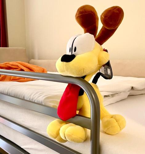 a stuffed animal is sitting on a bed at SchlafGut AppartementHotel in Leipzig