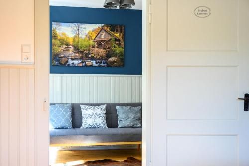 a door leading into a room with a painting of a house at Ferienhaus Ottenhöfen - Sauna | Hot Tub in Ottenhöfen