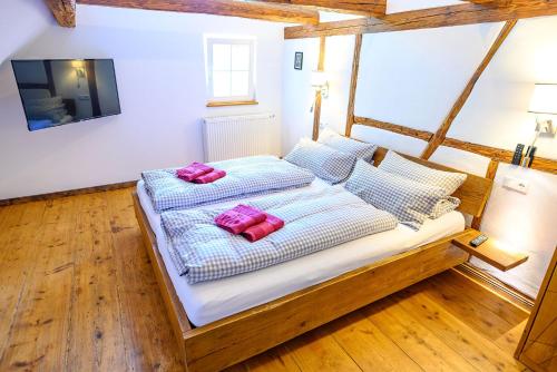 a bedroom with a bed with two pink pillows on it at Ferienhaus Ottenhöfen - Sauna | Hot Tub in Ottenhöfen
