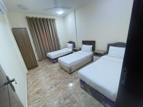 a hotel room with two beds in a room at Golden Seasons Furnished Apartment 7 in Salalah