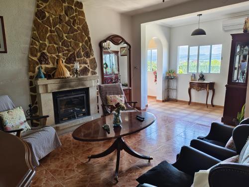 a living room with a table and a fireplace at Buenas vistas y privacidad, tranquila y fresca villa en el bosque de Valencia con una magnífica piscina de 80m2 in Lliria