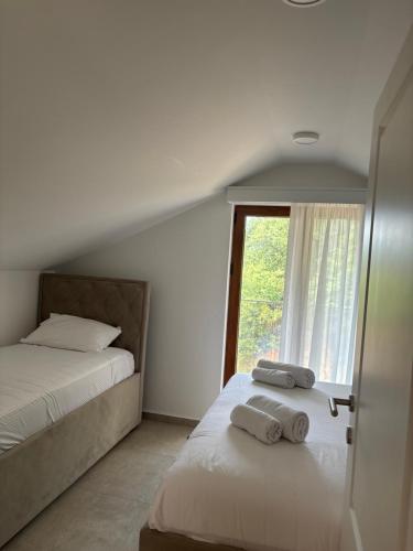 a bedroom with two beds and a window at Apartmani Milos - Meljine in Herceg-Novi
