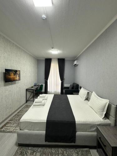 a bedroom with a large bed in a room at Beshchinor Hotel in Yakkasaray