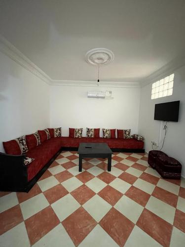 sala de estar con sofá rojo y suelo a cuadros en Ammour Apartment, en Chefchaouen