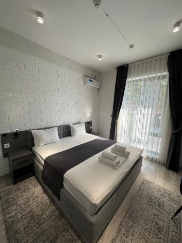 a bedroom with a large bed and a large window at Beshchinor Hotel in Yakkasaray