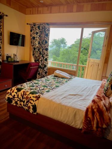 a bedroom with a bed and a large window at The Pineyard Pahalgam in Kolur