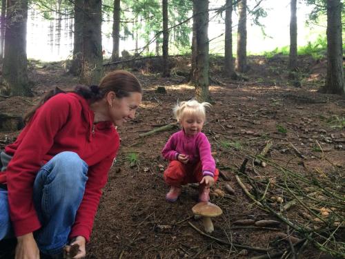 a woman and a little girl looking at a mushroom at Vila Kateřina in Broumov