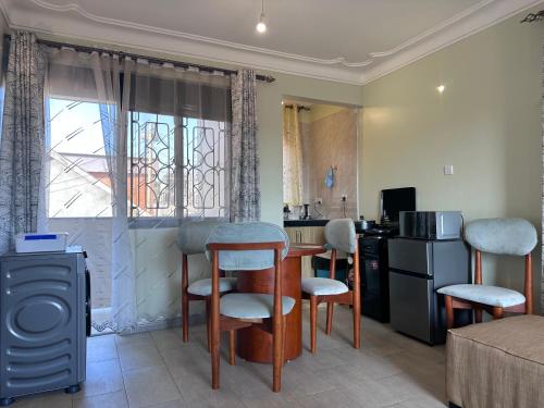 a living room with a table and chairs and a kitchen at 2Bedroom flat, free Wi-Fi near acacia mall in Nalakonge