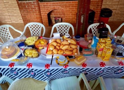 einen Tisch mit einem blauen und weißen Tischtuch mit Essen drauf in der Unterkunft Casa Top Arraial - Grupos e Famílias - 20 pessoas - 400 metros da praia in Arraial do Cabo