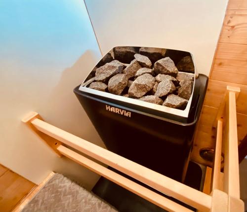 a black container of fire wood sitting on a shelf at 黒川温泉から車で10分、阿蘇一望の貸切サウナ&一棟貸切宿【Deepspot】 in Minamioguni