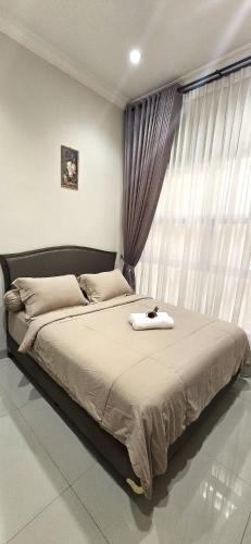 a bedroom with a large bed with a window at Ease Living Palem Kenari in Jatirarangan