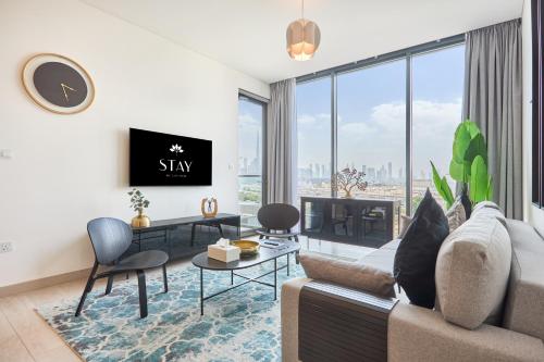 a living room with a couch and a tv at STAY BY LATINEM Luxury 2BR Holiday Home OPA 305 Near Downtown in Dubai