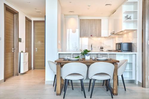 a kitchen with a wooden table and white chairs at STAY BY LATINEM Luxury 2BR Holiday Home OPA 305 Near Downtown in Dubai