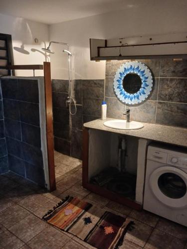 a bathroom with a sink and a washing machine at Villa du Nautique in Saint-Leu