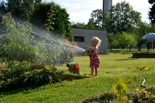 a little girl playing with a water hose at Vila Kateřina in Broumov