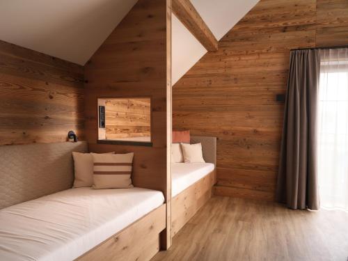 two bunk beds in a room with wooden walls at Hotel Bütgenbacher Hof in Butgenbach
