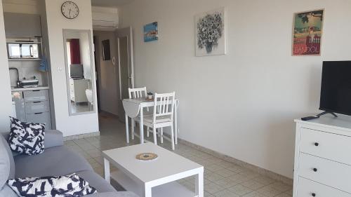 un salon avec un canapé et une table dans l'établissement Lumineux studio à Bandol, 2 pers, face à la plage, à Bandol