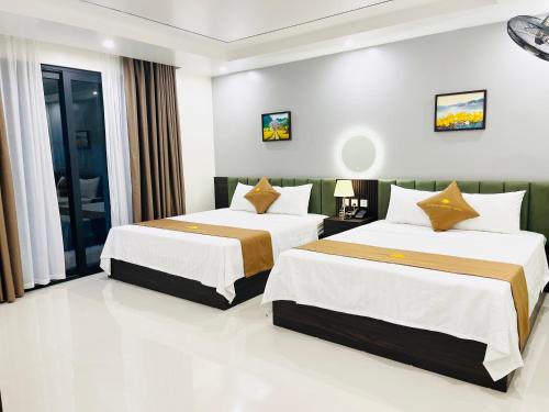 a hotel room with two beds in a room at Sunrise Airport Hotel - Noi Bai Airport in Thach Loi