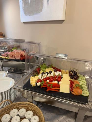 a tray of cheese and vegetables on a table at Altstadt Hotel Self Check-In in Würzburg