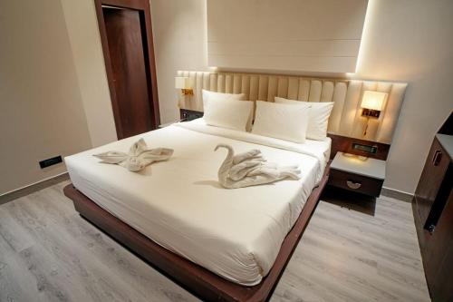 a bedroom with a bed with two swans on it at Hotel Midas Inn in Mathura