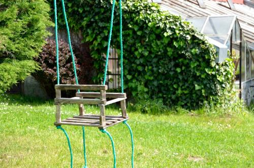 a wooden swing in the grass in a yard at Vila Kateřina in Broumov