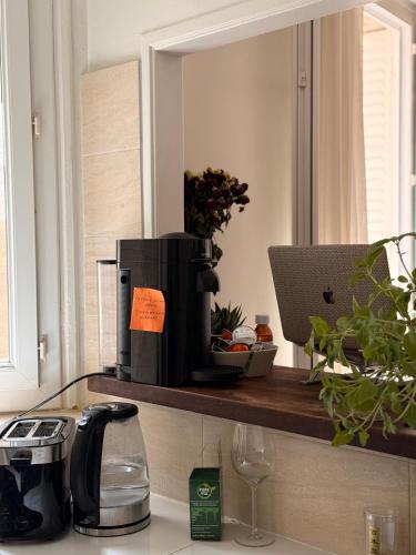 a kitchen counter with a coffee maker on a shelf at Stylish City Stay ,1-Bedroom ,Eiffel Tower Nearby in Vincennes