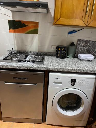 a kitchen with a stove and a washing machine at Cabo garden in Cabo Negro