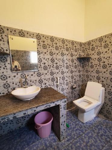 a bathroom with a sink and a toilet at Art Le Cafe in Auroville