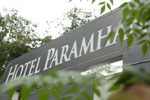 Un cartel que dice Hotel Palamanca está detrás de unos árboles. en Paramhans Hotel, en Rishīkesh
