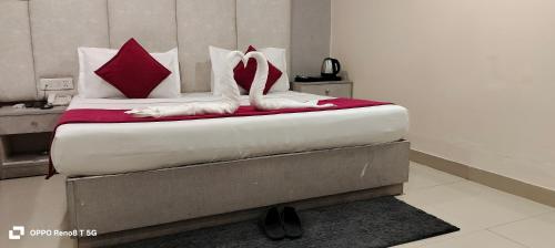 a bedroom with a bed with red and white pillows at The Grand Paramont Near Delhi Airport Free Airport Drop in New Delhi
