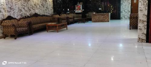 a living room with couches and tables in a building at The Grand Paramont Near Delhi Airport Free Airport Drop in New Delhi