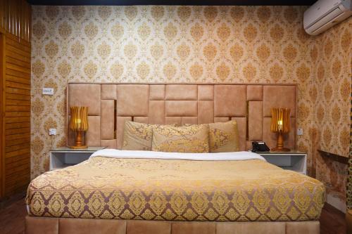 a bedroom with a large bed with two lamps at Royal Luxury Hotel Lahore in Lahore