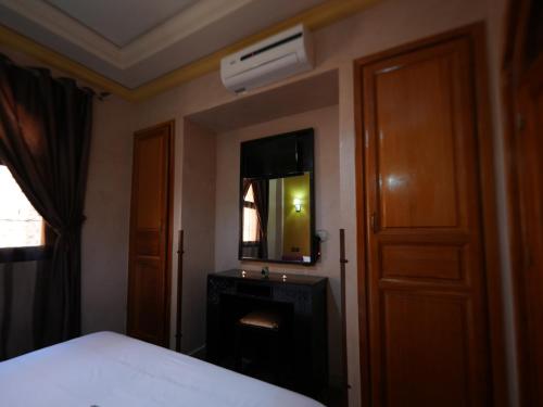 a bedroom with a bed and a mirror and a door at ApartHotel Nzaha in Tahannout