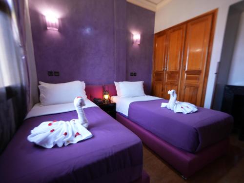 two beds in a hotel room with swans on them at ApartHotel Nzaha in Tahannout