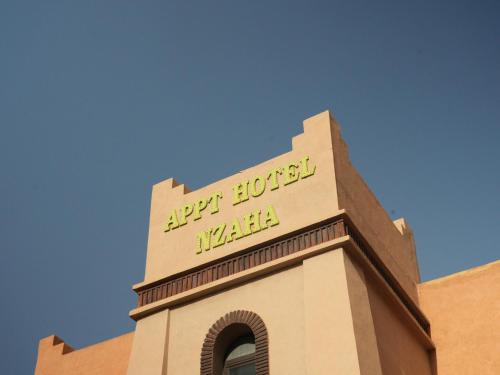 a building with a sign on top of it at ApartHotel Nzaha in Tahannout